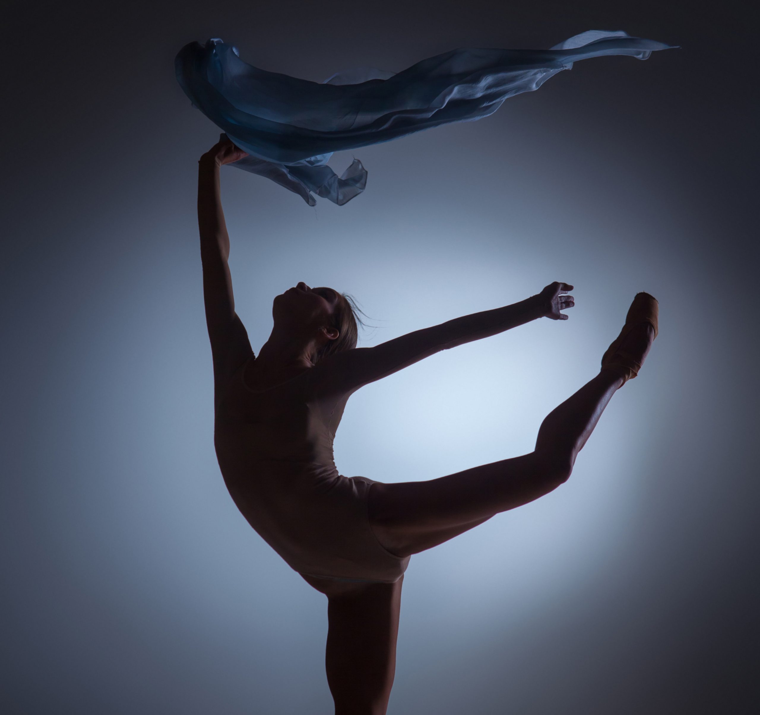 silhouette-beautiful-ballerina-dancing-with-veil-dark-blue-background